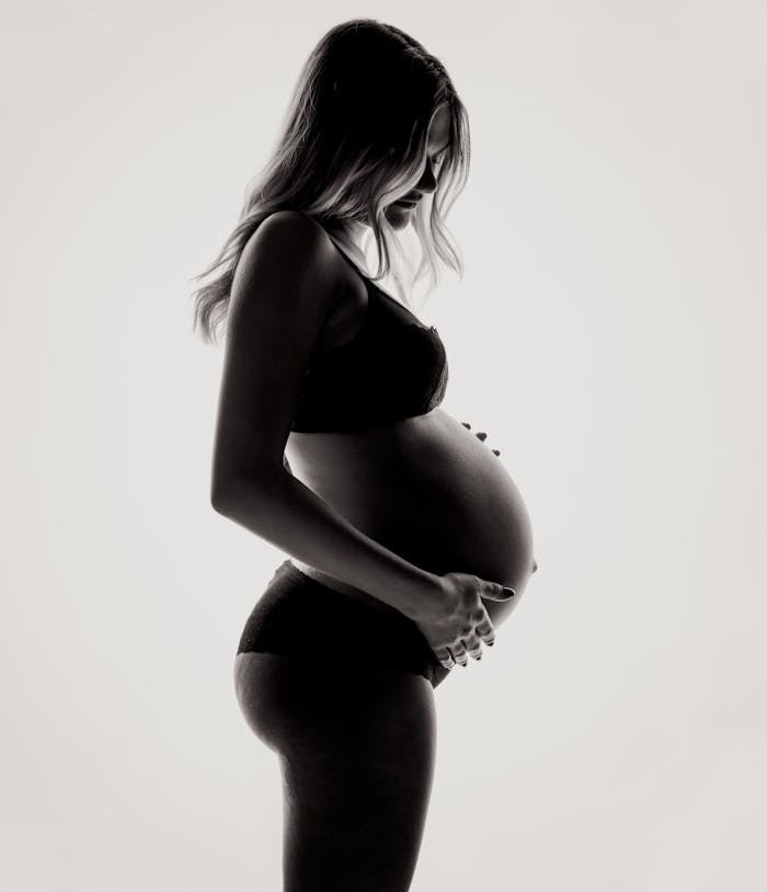 service-06 Silhouette of a pregnant woman in lingerie, expressing motherhood and contemplation.